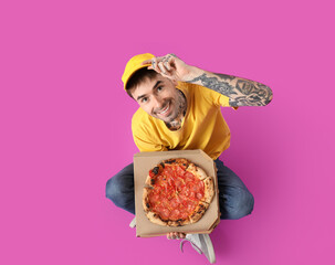 Sticker - Handsome tattooed young man with tasty pizza sitting on purple background