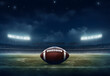 Leather American football ball on field at night