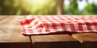 © Lasvu - Gingham napkin displayed on wooden table with natural blurred background.
