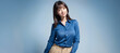 © WOWSTYLE - generative ai ブルー背景と笑顔の女性