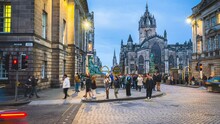 Time Lapse Of Crowded People Tourist Walking And Traveling Around David Hume Statue And St Giles' Cathedral At The Royal Mile High Street In Old Town, Edinburgh, Scotland, United Kingdom 