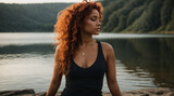 Fototapeta  - Bellissima ragazza con capelli rossi e ricci mentre fa yoga e meditazione in riva ad un lago	