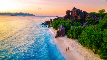 Wall Mural - Anse Source d'Argent, La Digue Seychelles, a young couple of Caucasian men and Asian women on a tropical beach during a luxury vacation in Anse Source d'Argent La Digue Seychelles a tropical Island 