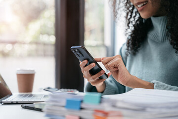 Happy black businesswoman using a smartphone play social in a creative office.