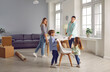 © Studio Romantic - Happy family couple with two kids boy and girl arranging furniture table and chairs in a new apartment on moving day with unpacked boxes in background. Relocating, real estate, mortgage concept.