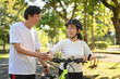 © Prathankarnpap - Beautiful active middle age couple with bicycle walking through park on sunny summer day.