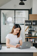 © laddawan - Asian businesswoman working with working notepad, tablet and laptop documents .