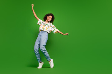 Wall Mural - Full length photo of cheerful pretty lady wear print shirt dancing empty space isolated green color background