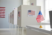 Empty Polling Station With Row Of White Voting Booths Decorated With American Flag At Vote Center. Presidential American Elections In The United States. Democracy And Election Day Concept.