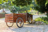 Fototapeta Sypialnia - Vintage wooden carts with empty stand on green garden under big tree