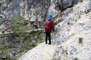 Careful Hiker Descending With the Help of an Iron Trail Security Wire on a Famous Travel Destination Hike in European Alps