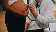 Female doctor is checking pregnant woman with stethoscope. Concept caring for pregnant woman