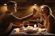 Romantic Relationship. Couple in love have dinner in cafe. Smiling man is feeding his woman. Celebrating Valentines Day