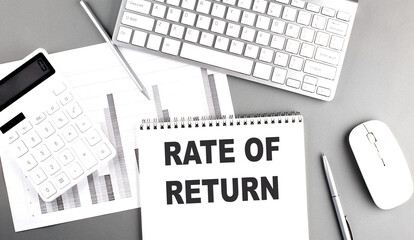 Poster - RATE OF RETURN text on a notebook with keyboard on grey background