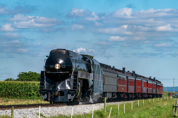 Wall Mural - A View of a Steam Passenger Train Approaching, Traveling Thru Rural America, Blowing Smoke on a Summer Day