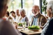 © Vorda Berge - Group of Happy Senior Friends Enjoying Meal Together