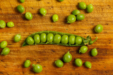 Green pea pods on a wooden table