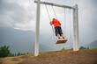 Boundless Energy: Man on Swings in Orange T-Shirt