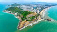 Vung Tau City Aerial View With Beautiful Sunset And So Many Boats. Panoramic Coastal Vung Tau View From Above, With Waves, Coastline, Streets, Coconut Trees And Tao Phung Mountain In Vietnam.
