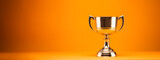 Fototapeta  - Classic gold trophy cup displayed on orange backdrop. Achievement and recognition theme. Generative AI