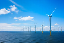 Wind Farm Located In The Ocean. It Features Multiple White Wind Turbines Installed On Yellow Platforms Anchored Into The Water