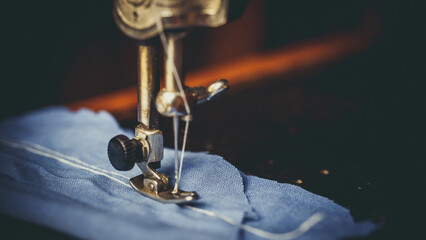 Wall Mural - Vintage sewing machine, man sews on a vintage sewing machine, retro sewing machine