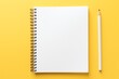 a notebook and pencil on a yellow background