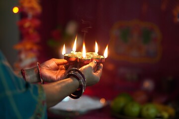 Wall Mural - a female hand holding burning oil lamps