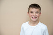 © epiximages - cool 11 years old boy with white t-shirt  in front of brown background in the studio