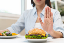 Woman On Dieting For Good Health Concept. Woman Doing Cross Arms Sign To Refuse Junk Food Or Fast Food Hamburger That Have Many Fat.