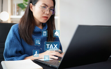 The concept of calculating taxes to be paid. Woman using computer to calculate tax through website and having headache paying taxes.