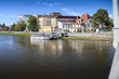 View of Vah River with small ship and buildings on riverbank (Piestany, Slovakia)