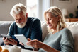 © DJSPIDA FOTO - happy couple senior man and woman Using a tablet together in the living room On a soft sofa, check family financial information, update good news Investment income Enjoy a great retirement.