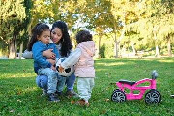 dominican mother teaching her kids to share the soccer ball. easing sibling rivalry.