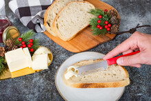 hand spreading butter on bread in festive lifestyle kitchen at christmas