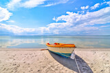 Fototapeta  - Samotna łódź na plaży nad morzem oceanem
