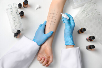 Doctor doing skin allergy test at light table, top view