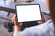 © Farknot Architect - Mockup image of a woman holding digital tablet with blank white desktop screen in cafe