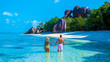 Anse Source d'Argent beach La Digue Island Seychelles, a couple of men and woman walking at the beach at a luxury vacation. a couple swimming in the turqouse colored ocean