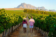 © Fokke Baarssen - Vineyard landscape at sunset with mountains in Stellenbosch Cape Town South Africa. wine grapes on the vine in a vineyard, a couple man and woman walking in a Vineyard in Stellenbosch