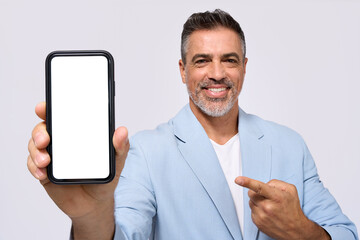 Happy middle aged older business man wearing suit holding smartphone in hand showing big mockup mobile screen pointing at cellphone advertising new banking phone app isolated on white background.