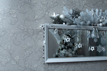 Wall Mural - A mirror decorated with a garland and a reflection of a Christmas tree	