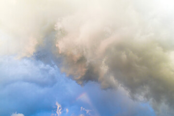 Wall Mural - Background of summer cloudy sky with tiny rainbow