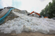 Farmers use excavators to organize crushed ice cubes.