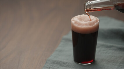 Wall Mural - pour dark berry drink in tumbler glass on walnut table with copy space