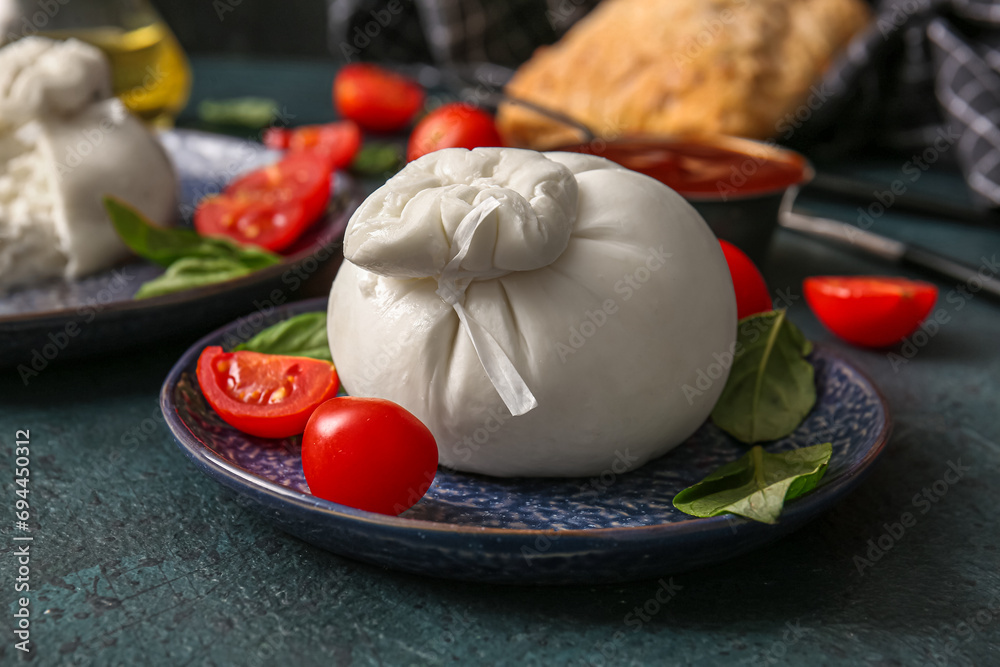 Plate with tasty Burrata cheese on blue background