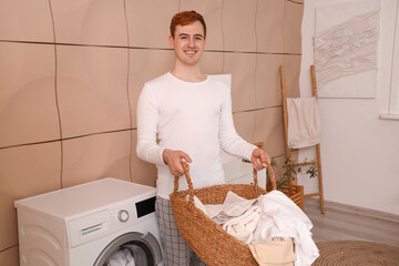 Wall Mural - Young man with laundry basket at home