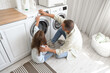 © Pixel-Shot - Mature man with his little granddaughter doing laundry at home
