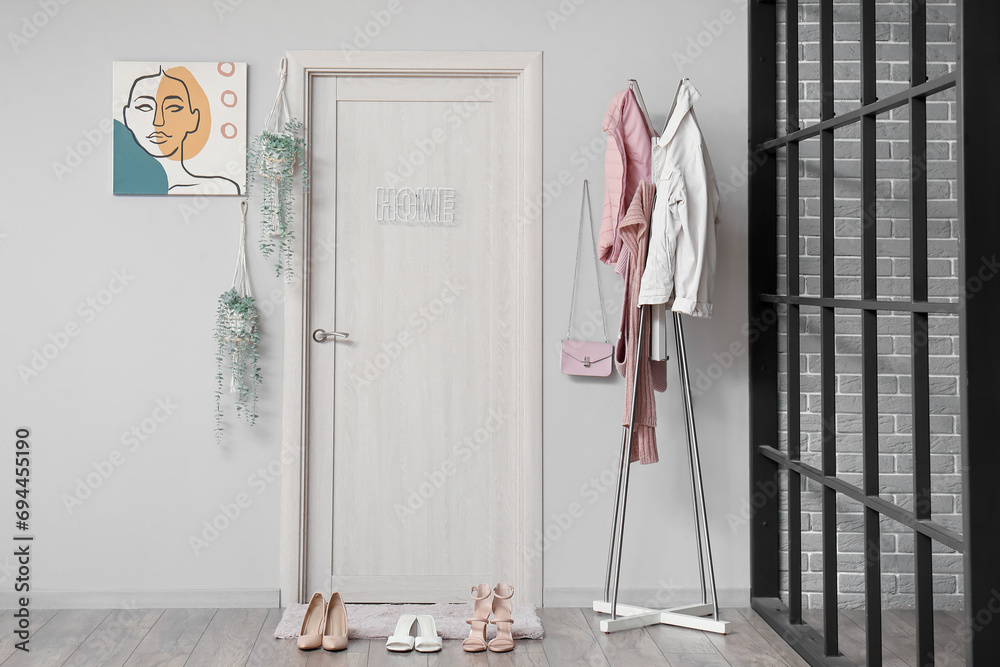 Interior of hall with door, mat and clothes rack