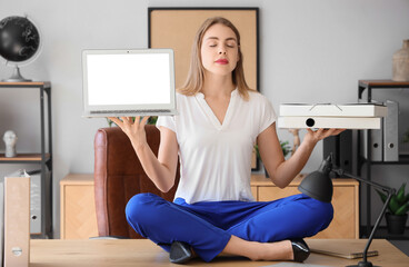 Poster - Young businesswoman with laptop and folders meditating on table in office